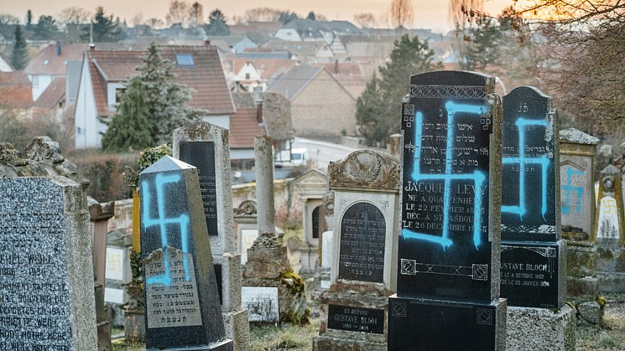 Sunset over the Jewish cemetery in Quatzenheim near Strasbourg, France, where gravestones were damaged and vandalized with swastikas in spray-painted in blue, February 2019. Credit: Hadrian/Shutterstock.