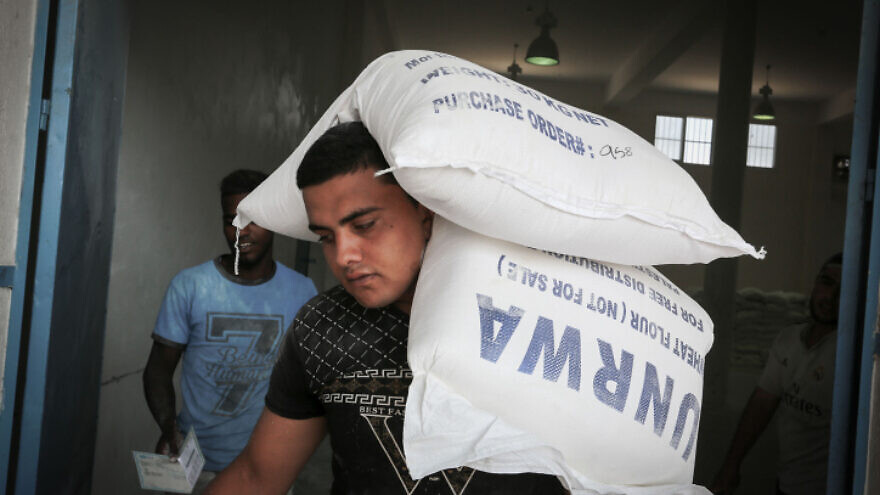 A Palestinian carries aid from UNRWA in Rafah, the southern Gaza Strip, Sept. 27, 2018. Photo by Abed Rahim Khatib/Flash90.