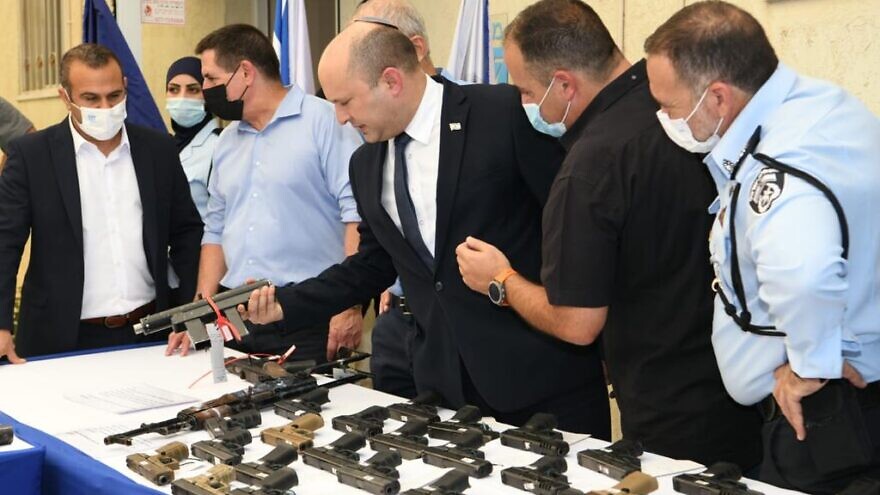 Israeli Prime Minister Naftali Bennett inspects illegal weapons seized during the Israel Police's "Operation Sword Strike" in the country's Arab sector, Aug. 11, 2021. Photo by Amos Ben-Gershom/GPO.