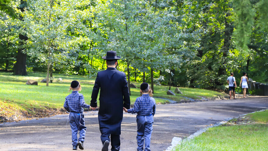 A Jewish man and his children walking in a park. Credit: Shutterstock.