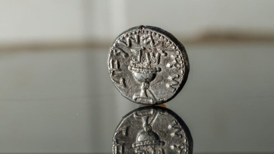 A 2,000-year-old silver coin found in debris from an excavation in the City of David, Jerusalem. The inscription reads, "Shekel Yisrael." Above the chalice are the Hebrew letters "shin" and "bet," an acronym for "Shana Bet," or year two of the Jewish revolt against Rome. Credit: Eliyahu Yanai/City of David.