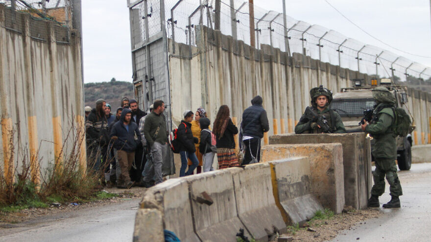 IDF soldiers guard the Homesh checkpoint while mourners enter for the funeral procession of Yehuda Dimentman, who was killed by a Palestinian terrorist, Dec. 17, 2021. Photo by Nasser Ishtayeh/Flash90.