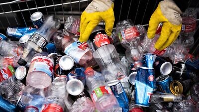 A man sorts bottles for recycling in Givat Shaul, Jerusalem, on Feb. 1, 2022. Photo by Nati Shohat/Flash90.