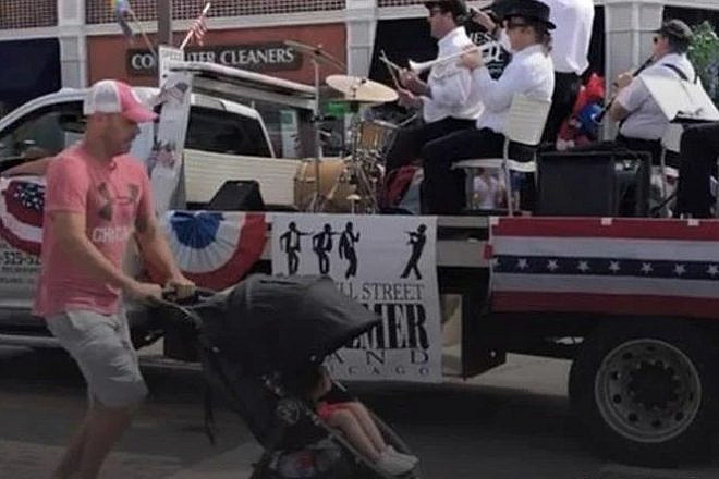 A father rushes his child to safety as gunshots are fired at a Fourth of July parade in Highland Park, Ill., on July 4, 2022. Credit: @LynnSweet/Chabad.org News.