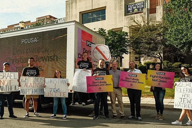 Participants in the “Sidewalk Stand Against Antisemitism” hold signs in front of a mobile billboard reading “Don’t Wreck Jewish-Christian relations” near the Presbyterian Church (U.S.A.) headquarters in Louisville, Ky., June 28, 2022. Credit: Courtesy of the Philos Action League and Pathways for Peace.
