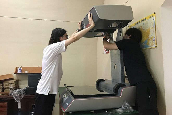 Staff members at the Central State Historical Archives of Ukraine in Lviv prepare to use the donated scanner. Credit: Courtesy of JewishGen.