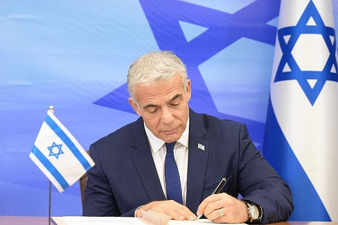 Then-Israeli Prime Minister Yair Lapid signs the U.S.-mediated maritime border and natural-gas deal with Lebanon, Oct. 27, 2022. Credit: Amos Ben-Gershom/GPO.