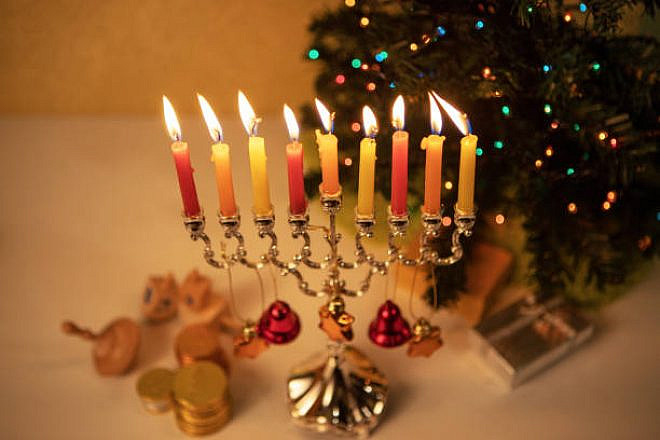 A Chanukah menorah next to a Christmas tree. Credit: Wikimedia Commons.