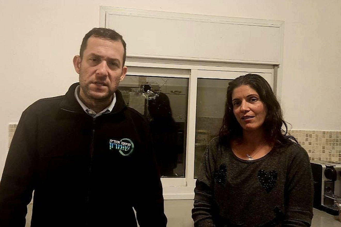 Samaria Regional Council head Yossi Dagan and Shaked resident Limor Merom, Jan. 15, 2023. Visible in the background is a hole in Merom's kitchen window made by a bullet fired by Palestinian terrorists. Credit: Samaria Regional Council.