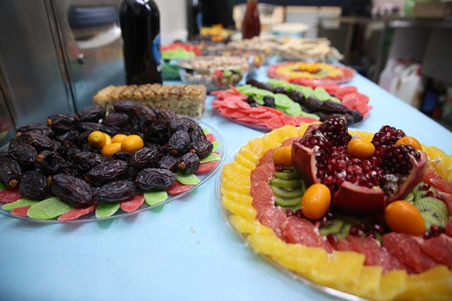 A table full of fruits and nuts, traditionally eaten for the Tu B'Shevat holiday, at the Rashbi's gravesite in Meron, Jan. 16, 2022. Photo by David Cohen/Flash90.