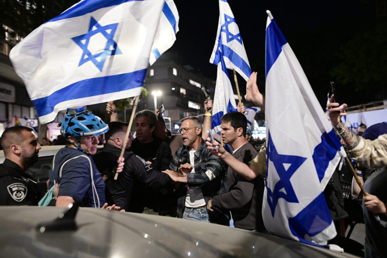 Police officers stand guard while Israelis demonstrate against Prime Minister Benjamin Netanyahu's wife, Sara Netanyahu, outside a hair salon in Tel Aviv, March 1, 2023. Photo by Avshalom Sassoni/Flash90.