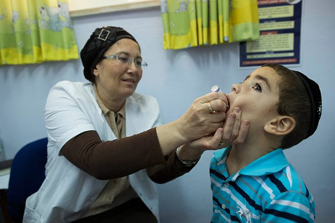 A boy is vaccinated against polio in the Neve Yaakov neighborhood of Jerusalem, Sept. 10, 2013. Photo by Yonatan Sindel/Flash90.