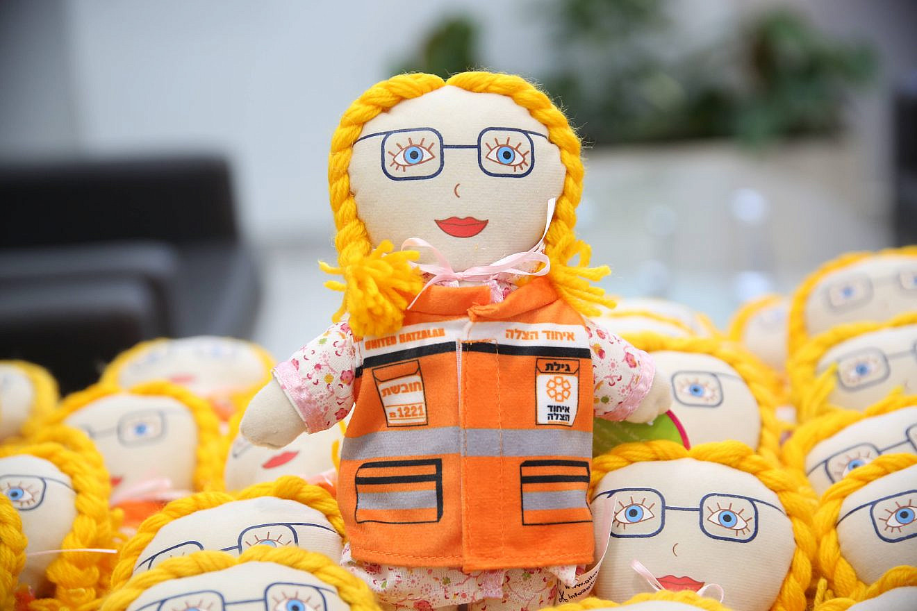 A doll to help children undergoing trauma and resembling the late Gilat Eisenmann, 11, dons a United Hatzalah vest. Credit: United Hatzalah.