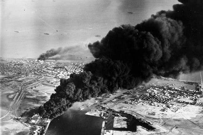 Smoke rises from oil tanks beside the Suez Canal hit during the initial Anglo-French assault on Port Said, Egypt, in November 1956. Credit: Wikimedia Commons.