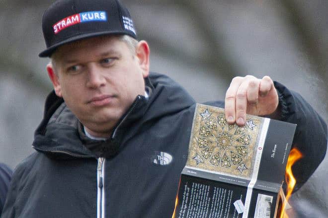 Libertarian Rasmus Paludan burns a translation of the Koran during a demonstration outside the Turkish embassy in Stockholm. Jan. 21, 2023. Photo by Tobias Hellstren via Wikimedia Commons.