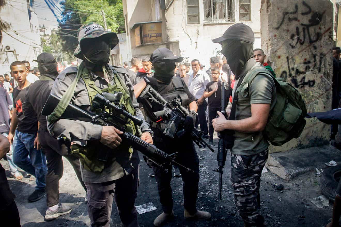 Palestinian gunmen near a damaged house following an Israeli military raid at the Nur Shams refugee camp, east of Tulkarm, on Sept. 5, 2023. Photo by Nasser Ishtayeh/Flash90.