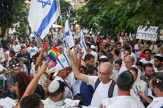 Jews pray while activists protest against gender segregation during a public prayer at Dizengoff Square in Tel Aviv on Yom Kippur, Sept. 25, 2023. Credit: Itai Ron/Flash90.