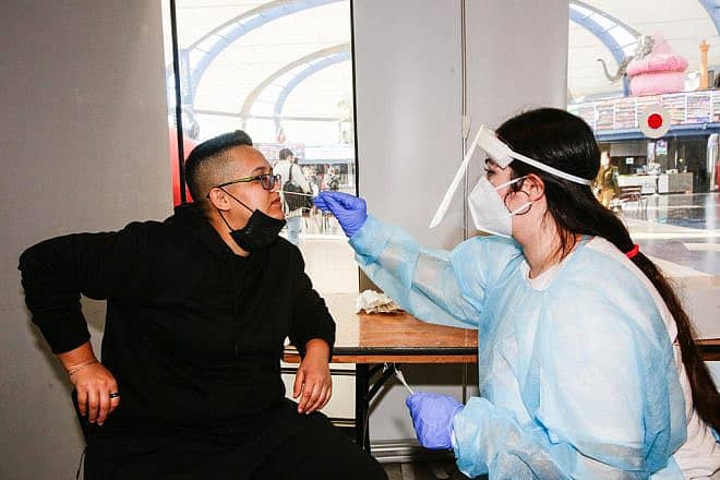 A nurse collects a swab sample from at a coronavirus testing center in Jerusalem, Jan. 6, 2022. Photo by Shalev Shalom/TPS.