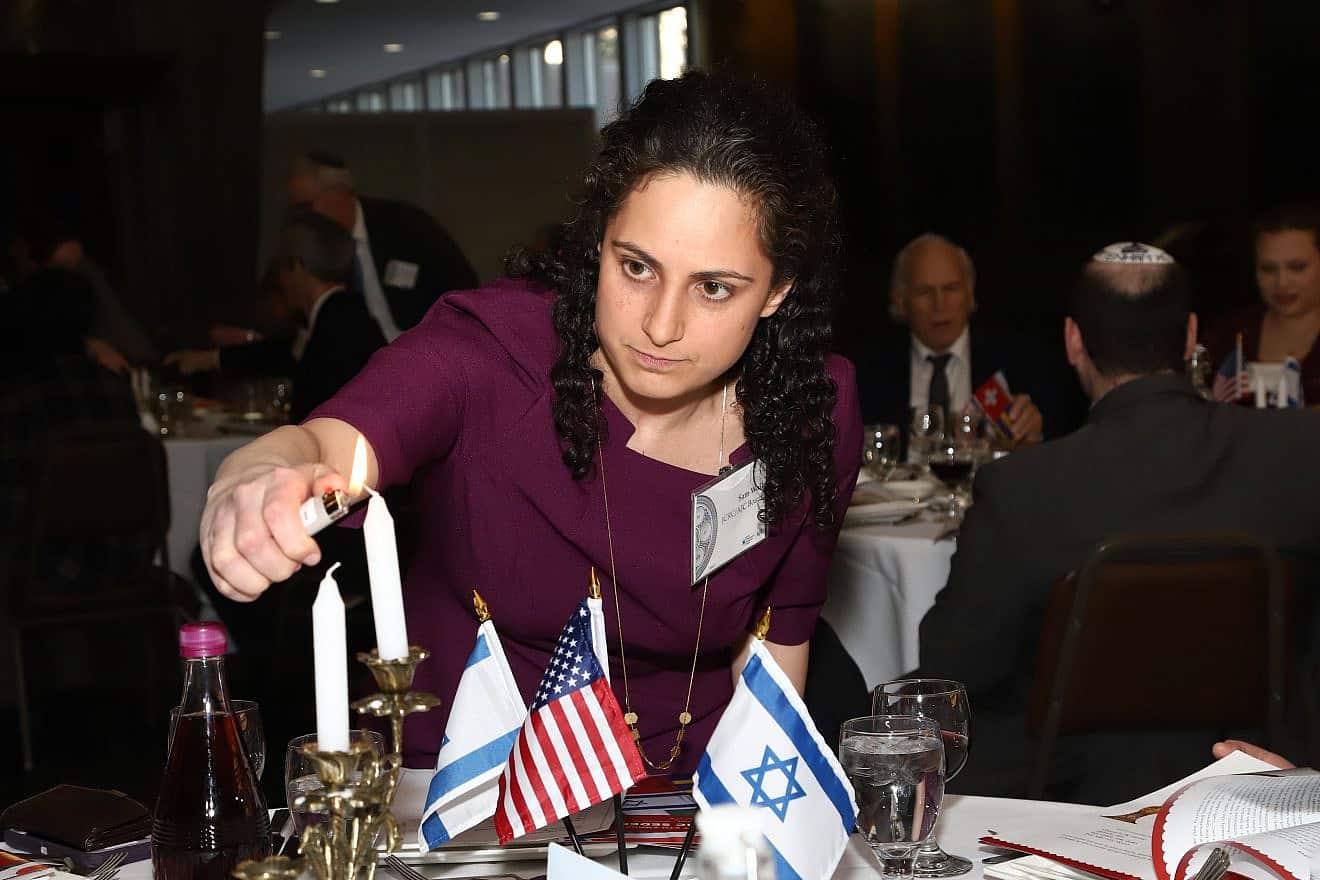JCRC/AJC board member Samantha Woll lighting candles in March 2018. Credit: Courtesy of JCRC/AJC.