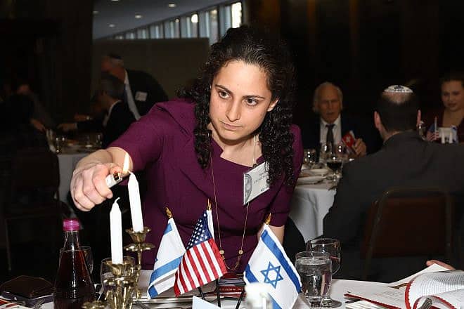 JCRC/AJC board member Samantha Woll lighting candles in March 2018. Credit: Courtesy of JCRC/AJC.