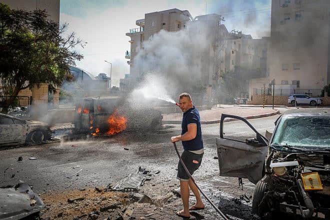 A man works to extinguish a fire ignited by a Gazan rocket strike in Ashkelon, Oct. 7, 2023. Photo by Jamal Awad/Flash90.