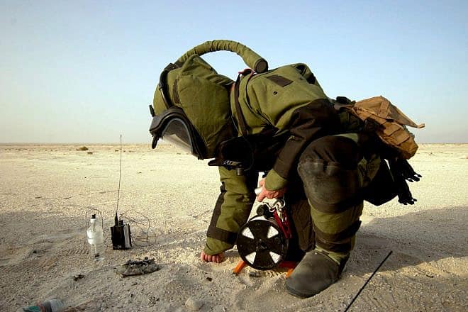 Hull Maintenance Technician 2nd Class Carl Harris inspects remaining high explosive material from a disrupted improvised explosive device during a training exercise in Bahrain in May 2005. Credit: U.S. Navy Photo by Photographer's Mate 1st Class Aaron Ansarov.