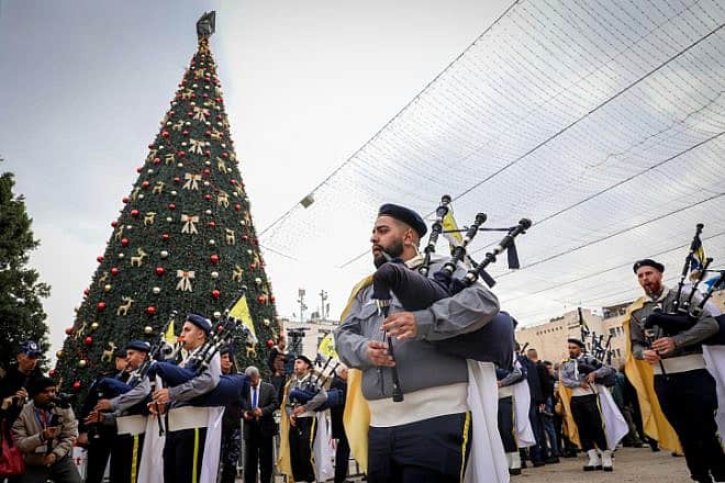 Palestinians march during a Christmas parade outside the Church of the Nativity on the eve of Christmas, Dec. 24, 2022. Photo by Wisam Hashlamoun/Flash90.