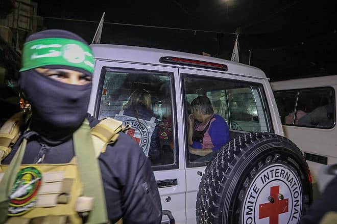 A Hamas terrorist releases Israeli hostages to the Red Cross, in Rafah, the southern Gaza Strip, Nov. 28, 2023. Credit: Flash90.