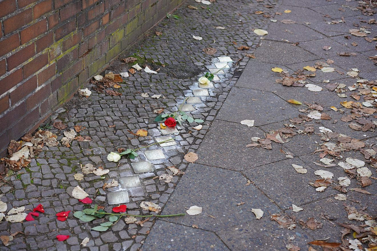 Freshly polished Stolpersteine (“stumbling stones”) in Berlin decorated with flowers marking the anniversary of Kristallnacht on Nov. 8, 2022. Credit: Achim Wagner/Shutterstock.