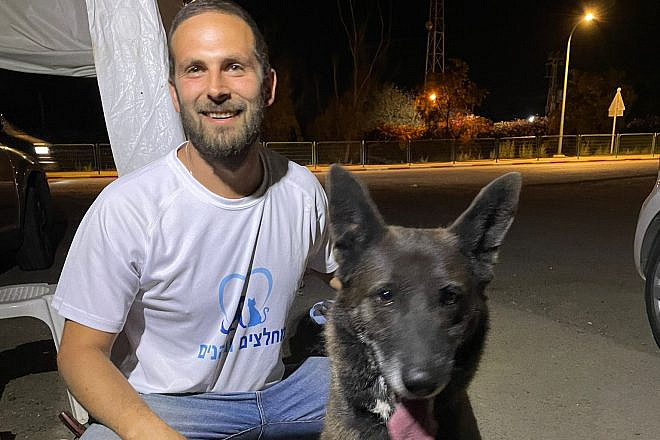 Adam Benett rescues a dog at a kibbutz in southern Israel. Credit: Courtesy.