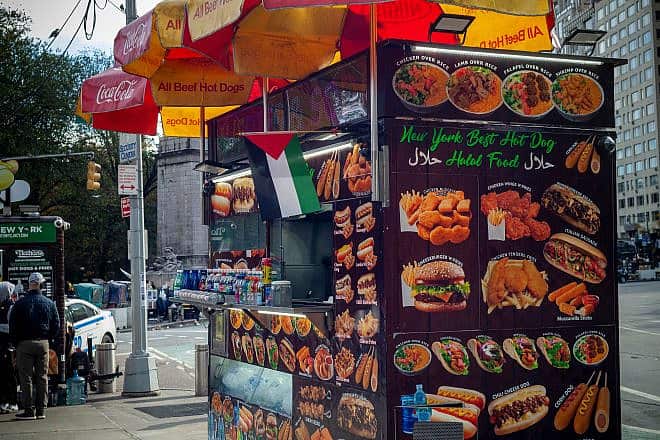 A Palestinian flag flies over a halal food cart in Columbus Circle in New York on Nov. 12, 2023. Credit: rblfmr/Shutterstock.