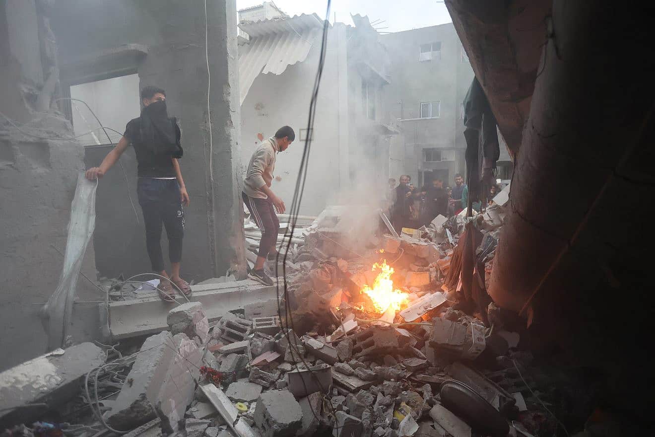 Palestinians at the site of an Israeli air strike in Khan Yunis, in the southern Gaza Strip, on Dec. 7, 2023. Photo by Atia Mohammed/Flash90.