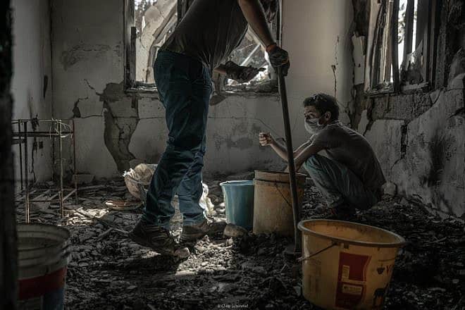 Members of a family whose father was murdered by Hamas terrorists on Oct. 7 search the rubble of his home in Kibbutz Be'eri on Nov. 30, 2023. Photo by Chen Schimmel/Flash90.