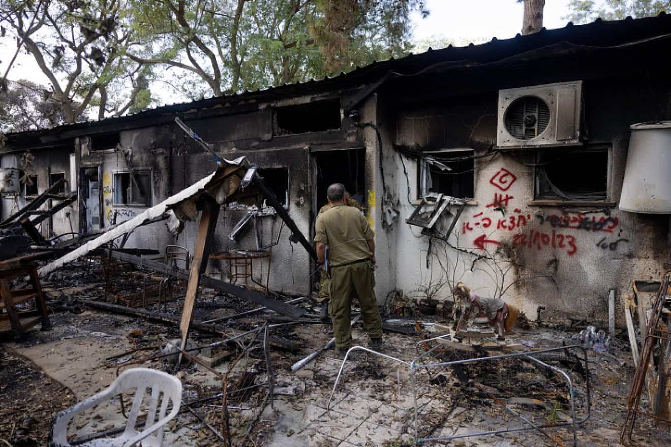 Members of the Israel Defense Forces walking next to destruction caused by Hamas terrorists in Kibbutz Nir Oz in southern Israel, Nov. 21, 2023. Photo by Chaim Goldberg/Flash90.