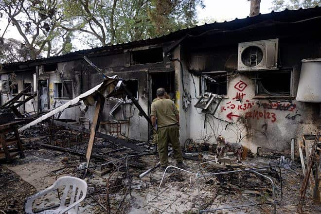 Members of the Israel Defense Forces walking next to destruction caused by Hamas terrorists in Kibbutz Nir Oz in southern Israel, Nov. 21, 2023. Photo by Chaim Goldberg/Flash90.