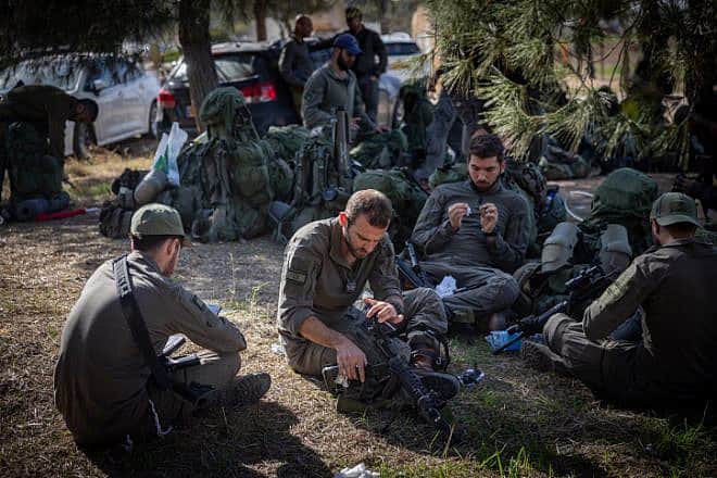 Israeli soldiers take a break before entering the Gaza Strip, Dec. 20, 2023. Photo by Yonatan Sindel/Flash90.