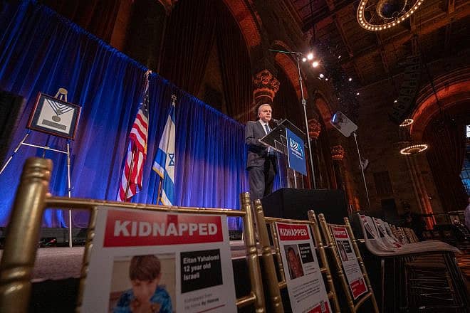 On November 13, 2023, Israel Bonds President & CEO Dani Naveh addresses guests at the organization’s Real Estate & Allied Division Luncheon in New York City, surrounded by empty seats in honor of the hostages abducted by Hamas. Photo by Shahar Azran.