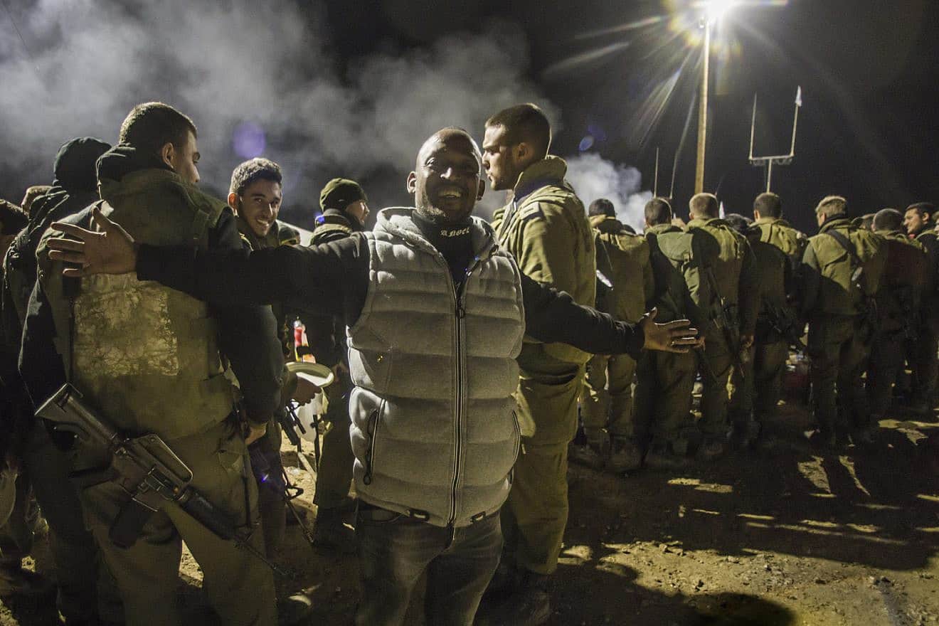 An Eritrean volunteer helps feed hungry Israel Defense Forces near the Gaza Strip, Jan. 16, 2024. Photo by Rina Castelnuovo.