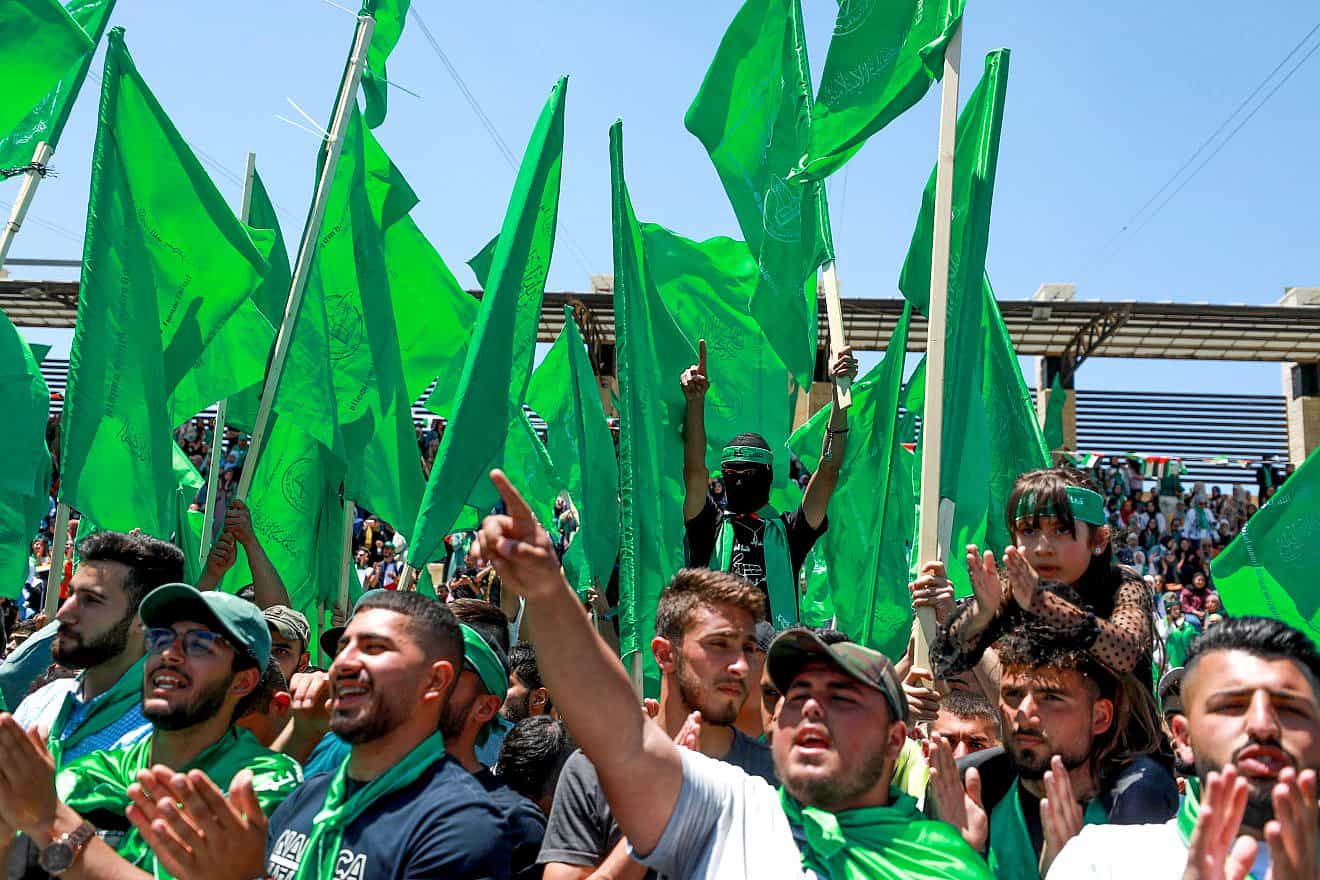 Hamas supporters wave the terrorist group's flag during a rally at Birzeit University, north of Ramallah, May 19, 2022. Credit: Flash90.