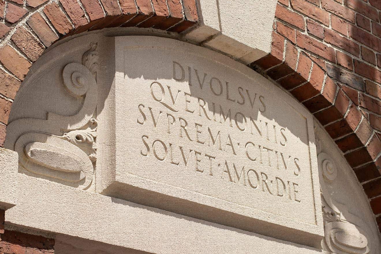 A close-up of the Latin inscription at the top right of the Class of 1857 Gate (Wadsworth Gate) to Harvard Yard, the oldest part of the Harvard University campus in Cambridge, Mass. Credit: Tada Images/Shutterstock.