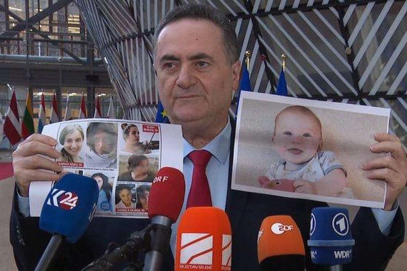 Israeli Foreign Minister Israel Katz holds up a photo of baby Kfir Bibas and a montage of several young women, all held hostage by Hamas in Gaza. Credit: MFA.