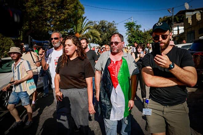 MK Ofer Cassif wears a PLO flag during a protest against the eviction of Arab families from Jewish-owned homes in the eastern Jerusalem neighborhood of Sheikh Jarrah, Sept. 8, 2023. Photo by Chaim Goldberg/Flash90.