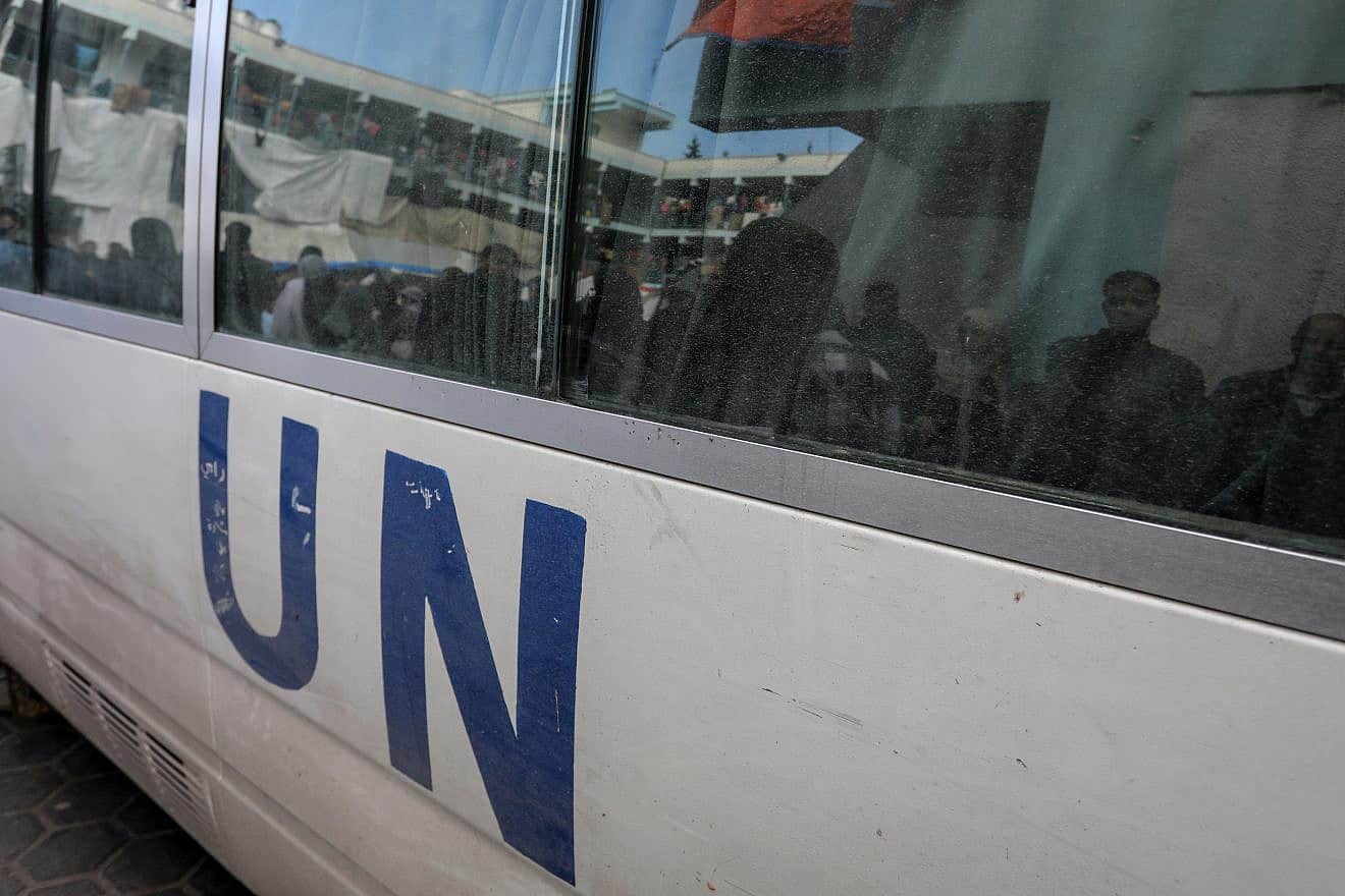 Palestinians looking for food at an UNRWA school are reflected in the windows of a United Nations vehicle in Gaza on Jan. 24, 2024. Credit: Anas-Mohammed/Shutterstock.