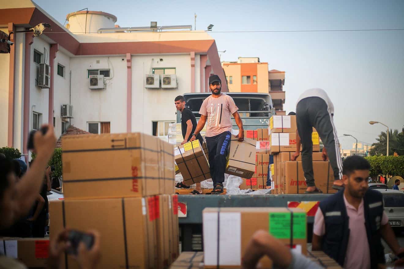 Palestinians unload medical aid from a truck at the Nasser Hospital in Khan Yunis, in the southern Gaza Strip, on Oct. 23, 2023.  Photo by Atia Mohammed/Flash90.