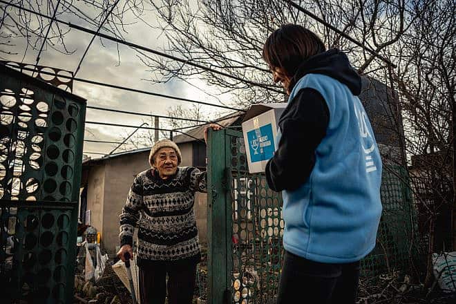 A JDC volunteer delivers emergency aid to Larisa Potanina, 86, an internally displaced Ukrainian Jew from the country's hard-hit east now living in Koshary, a small village outside of Odessa, and dependent on the organization for food, medicine and other support. Photo by Arik Shraga.