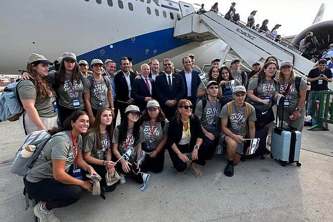 Israeli Aliyah and Integration Minister Ofir Sofer (standing, center) at Ben-Gurion International Airport with new immigrants from the United States who plan to enlist in the Israel Defense Forces. Credit: Courtesy.