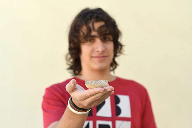 Yonatan Frankel and the lamp he found. Photo by Yoli Schwartz/Israel Antiquities Authority.