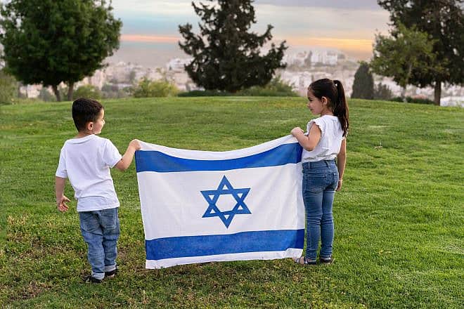 Young children hold an Israeli flag. Credit: Inna Reznik/Shutterstock.