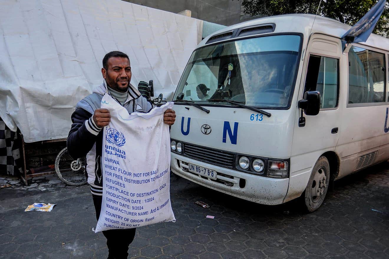 A Palestinian receives food at an UNRWA school in Rafah, the southern Gaza Strip, Jan. 28, 2024. Photo by Abed Rahim Khatib/Flash90.