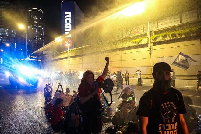 Police use a water cannon to disperse demonstrators blocking the Ayalon Highway in Tel Aviv, March 30, 2024. Photo by Itai Ron/Flash90.